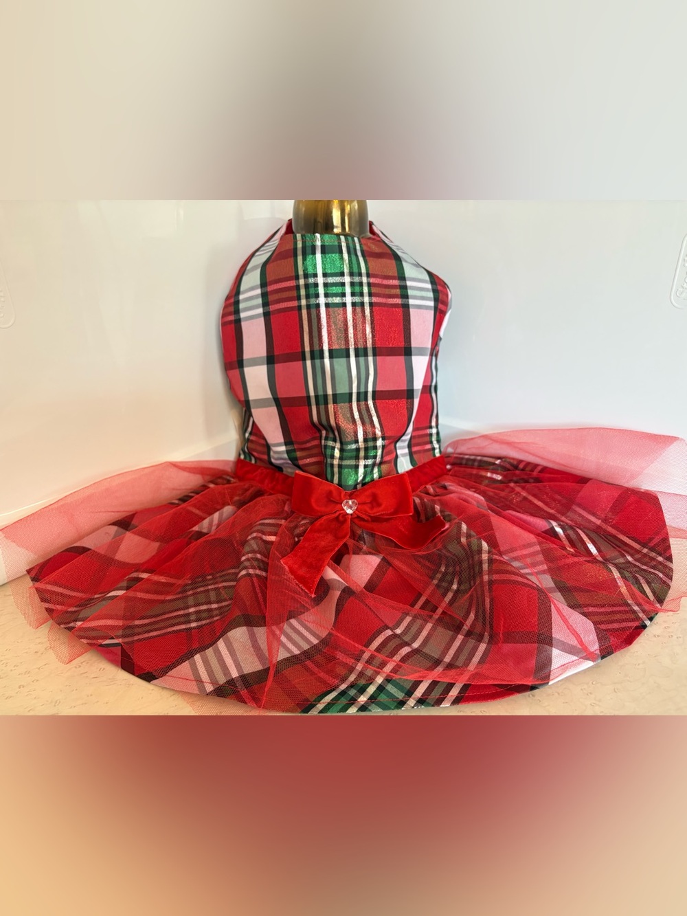 Festive red and green plaid pet dress features a charming layered tulle skirt.